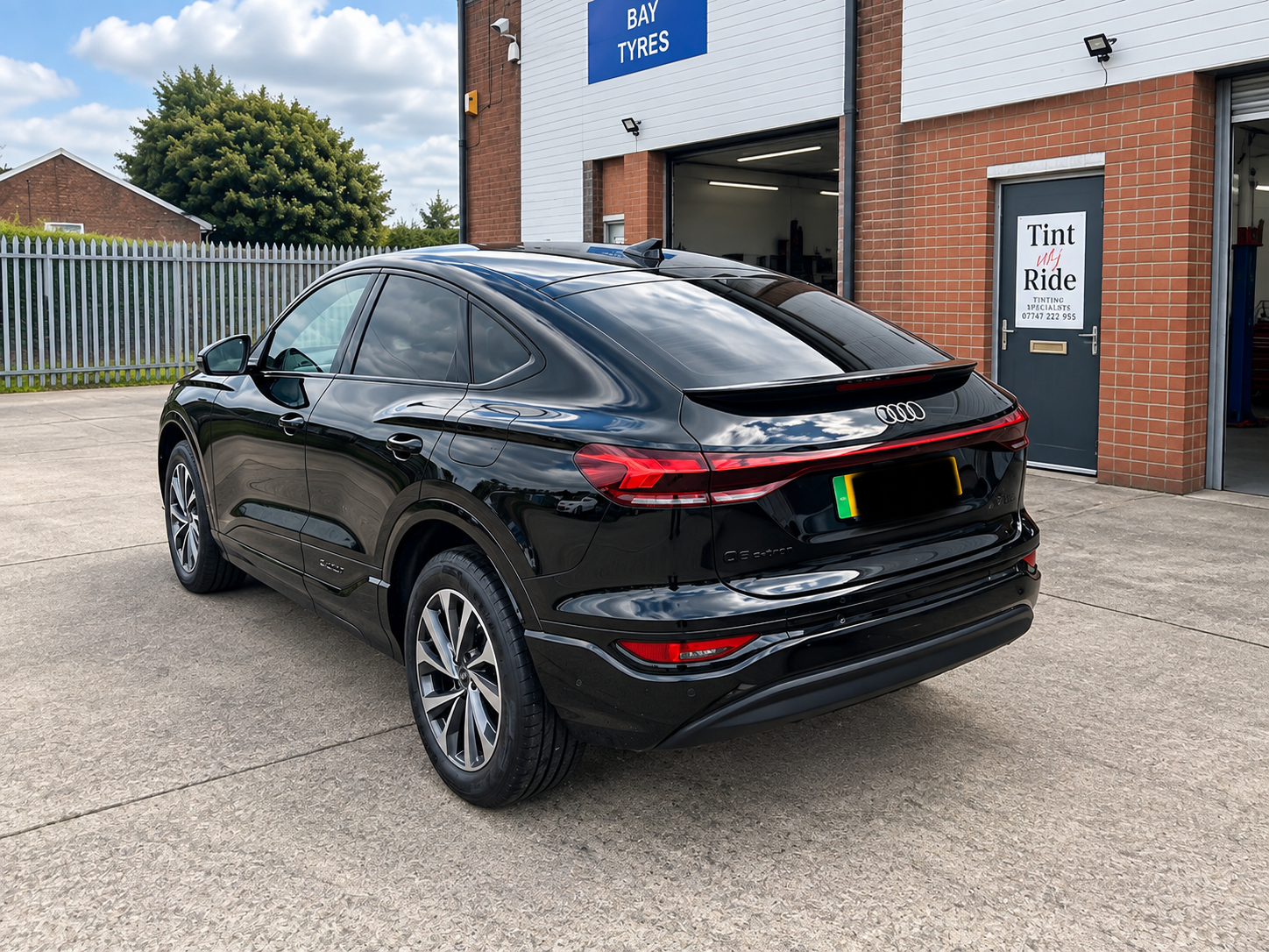 Black Audi SUV with dark rear window tint