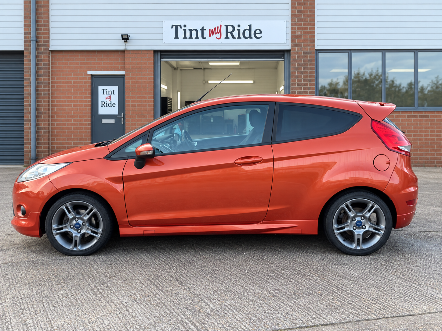 Orange Ford Fiesta with rear window tint