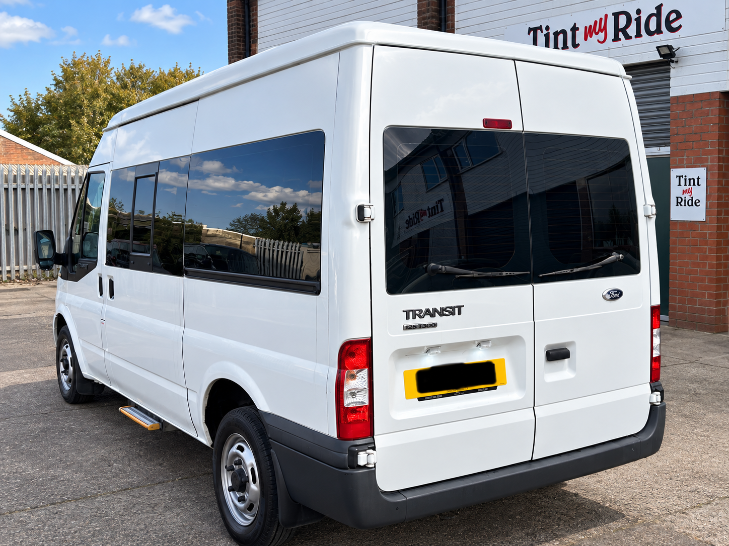 White Ford Transit minibus with tinted glass