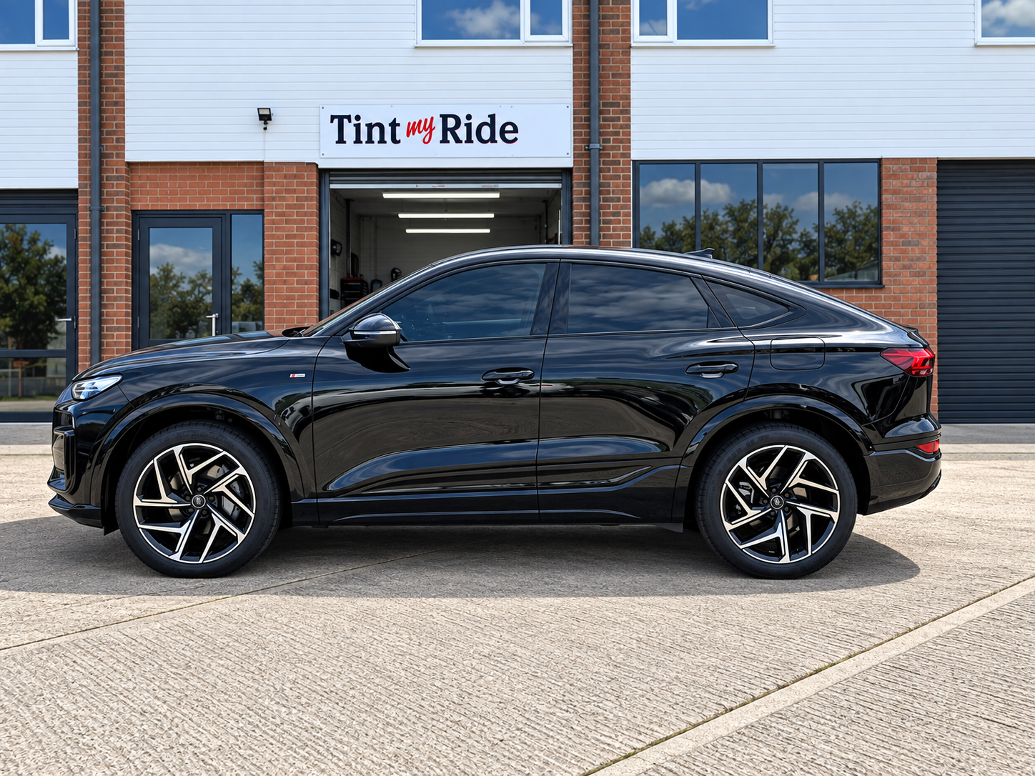 Black Audi coupe SUV with tinted rear windows