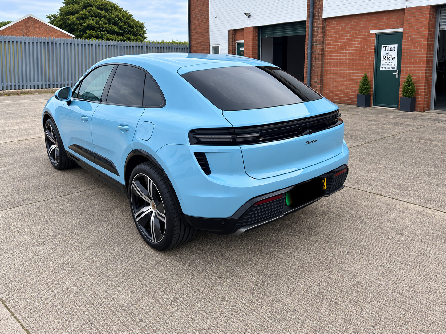 Blue Porsche Macan rear view with tinted glass