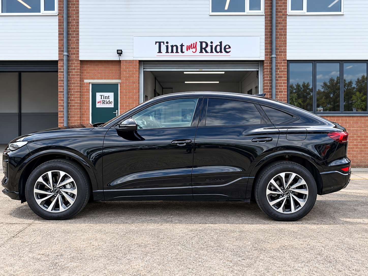 Black Audi Sportback side profile with tinted glass